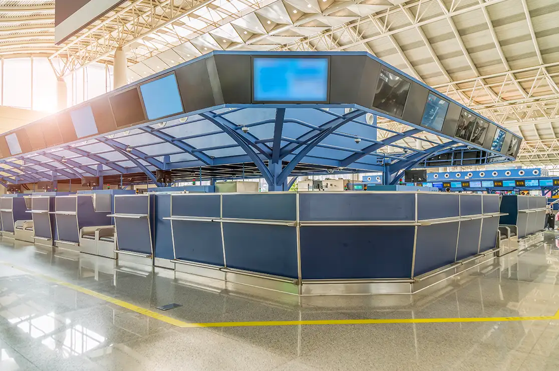 Airport terminal check-in counters beneath an exposed roof structure, illustrating airport interior design and BIM coordination.