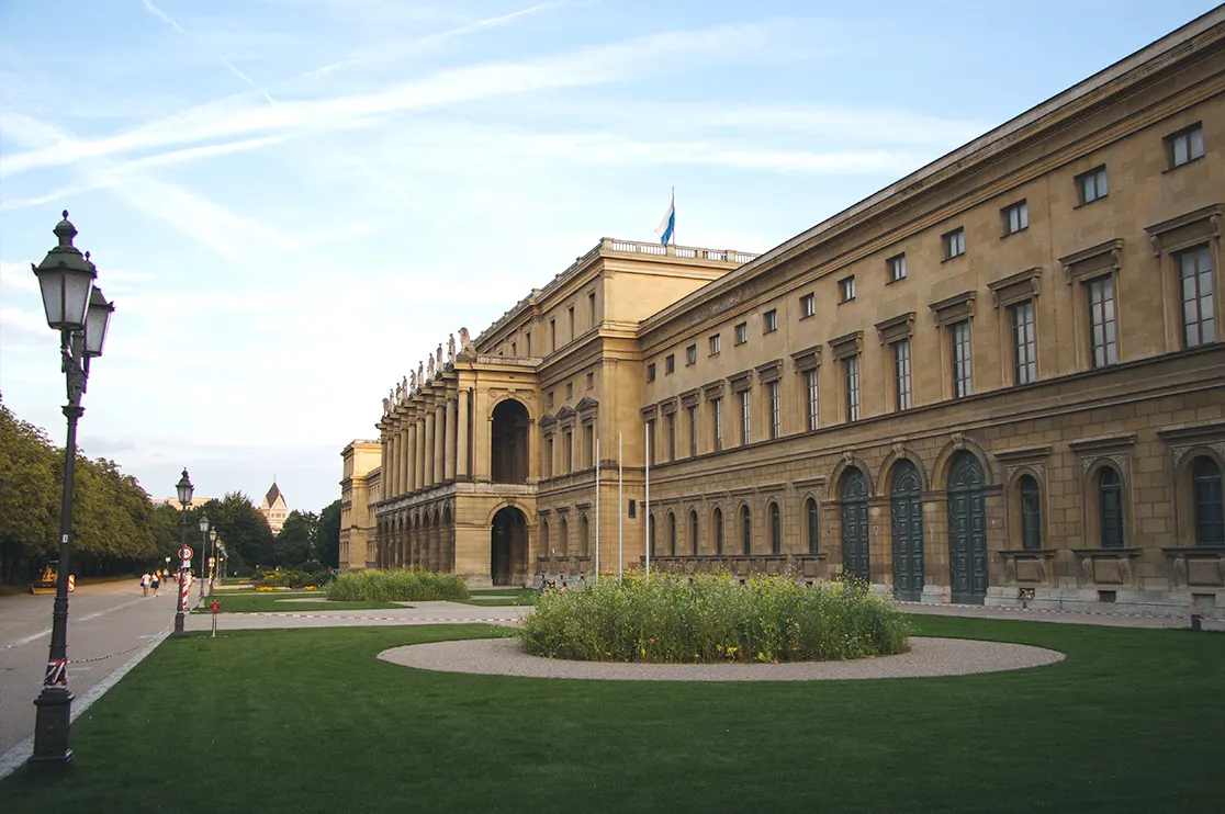A large institutional educational building with landscaped grounds, pedestrian pathways, and detailed architectural features. The image represents BIM applications in schools and higher educational facility development projects, from design and planning to construction coordination
