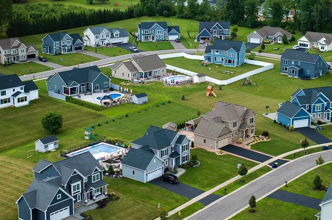 Aerial view of a residential community with homes, landscaped yards, roads, and shared amenities for BTR marketing