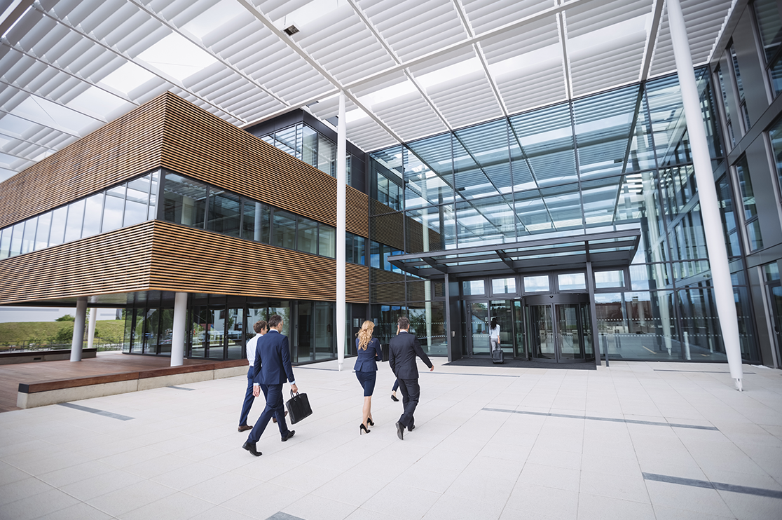 Business people entering a modern office building, illustrating commercial 3D rendering tips to prevent tenant rejection